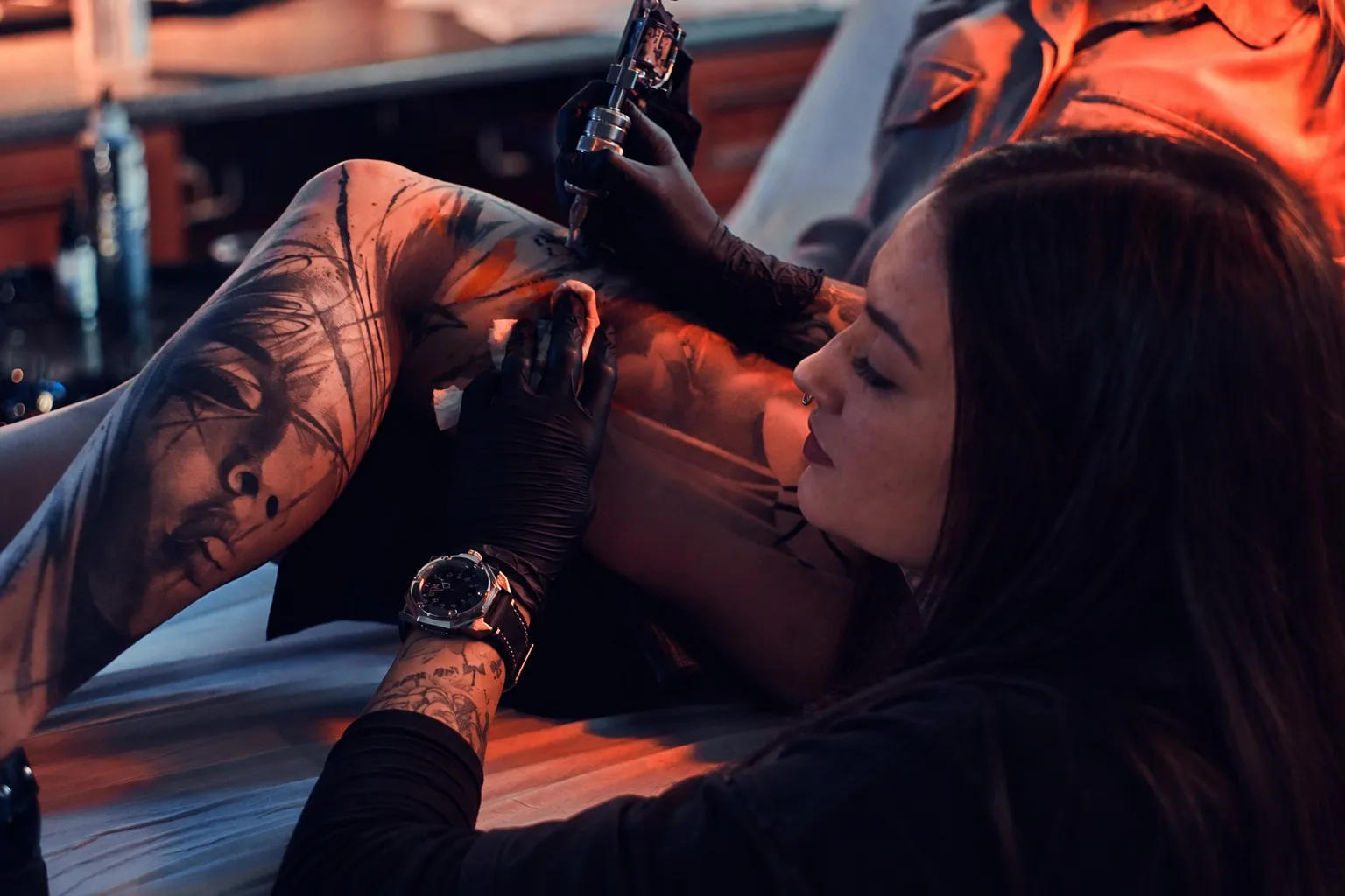 Laura Teixeira tatuando um projeto de realismo no estúdio